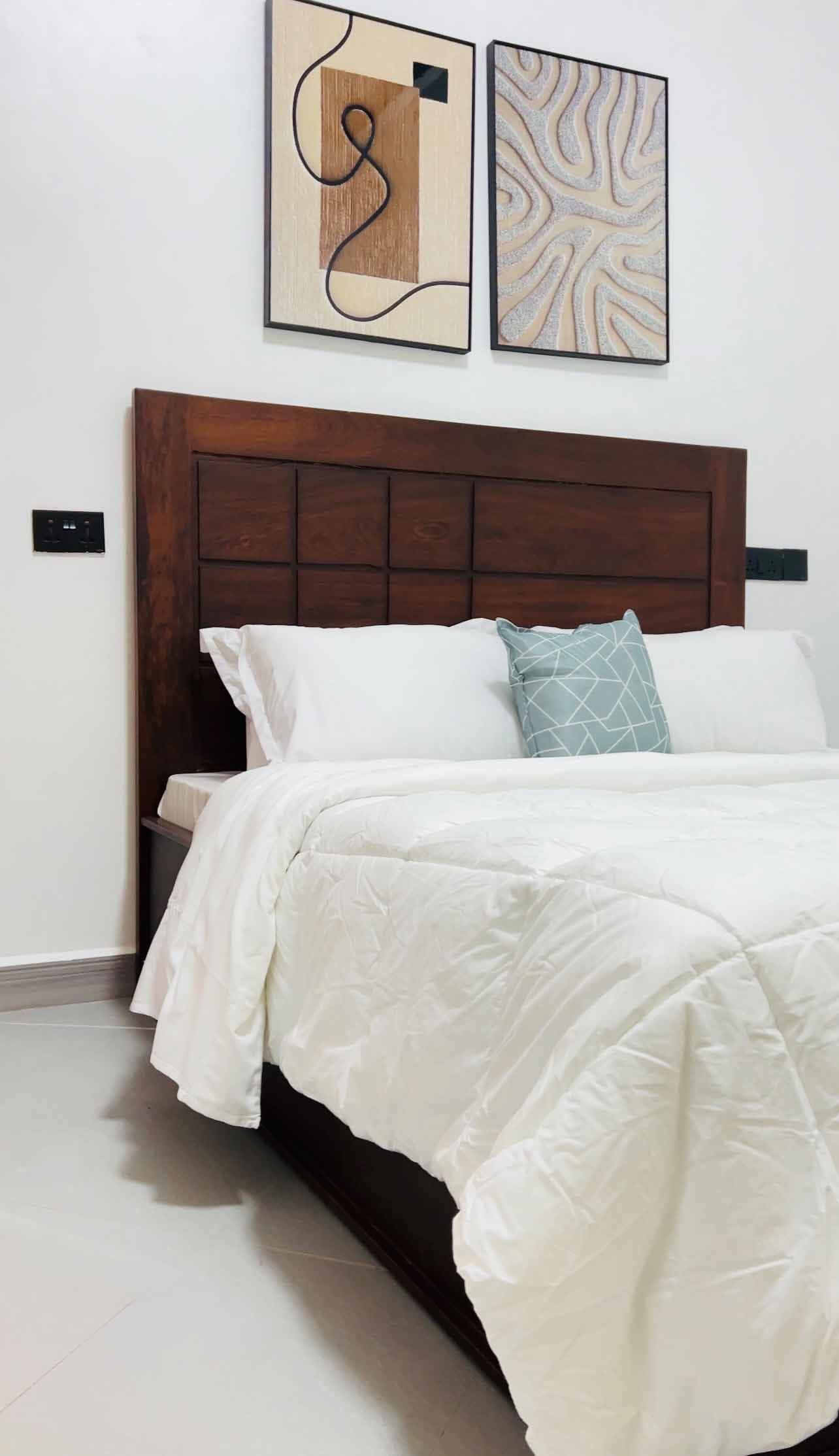 Executive Bedroom Suite with dark wood paneled bed, Egyptian cotton linens, and quiet garden aspect.